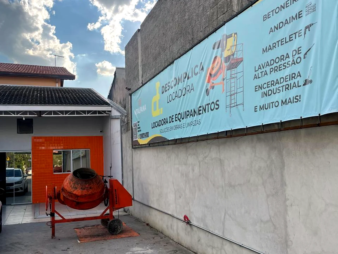 Fachada da Descomplica Locadora com betoneira no pátio